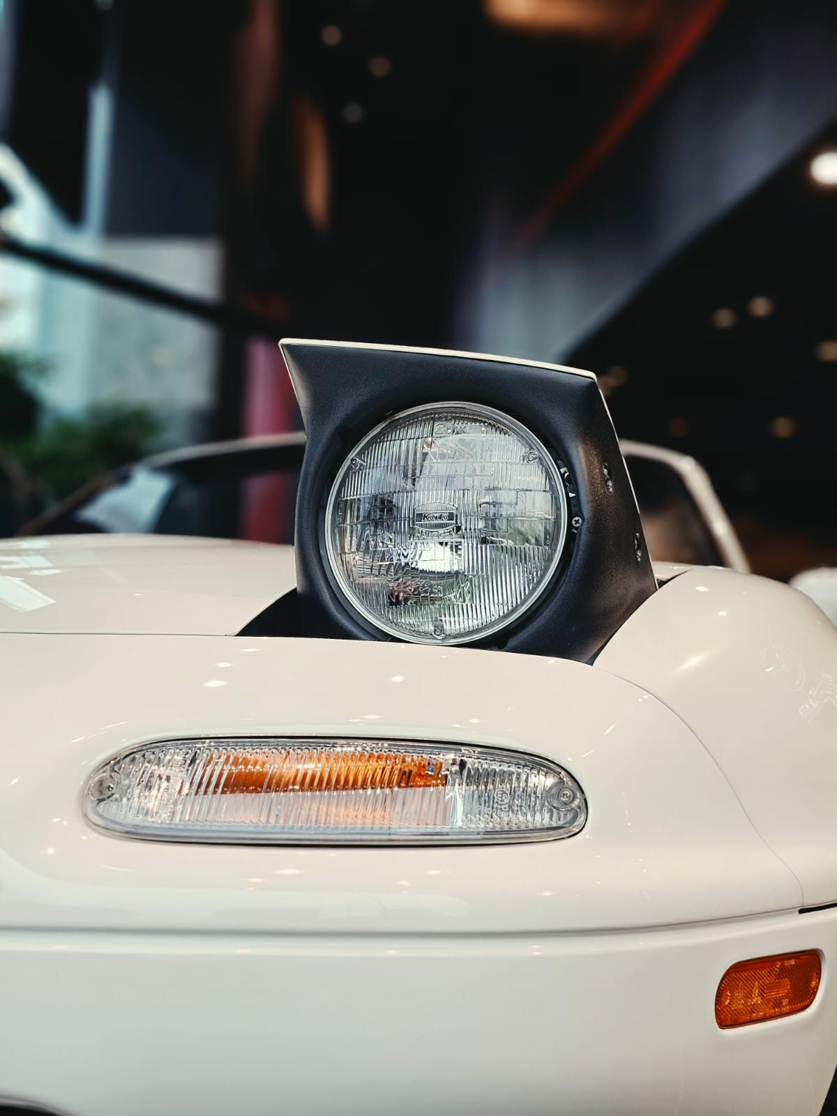 Close-up of a pop-up headlamp on the Eunos Roadster