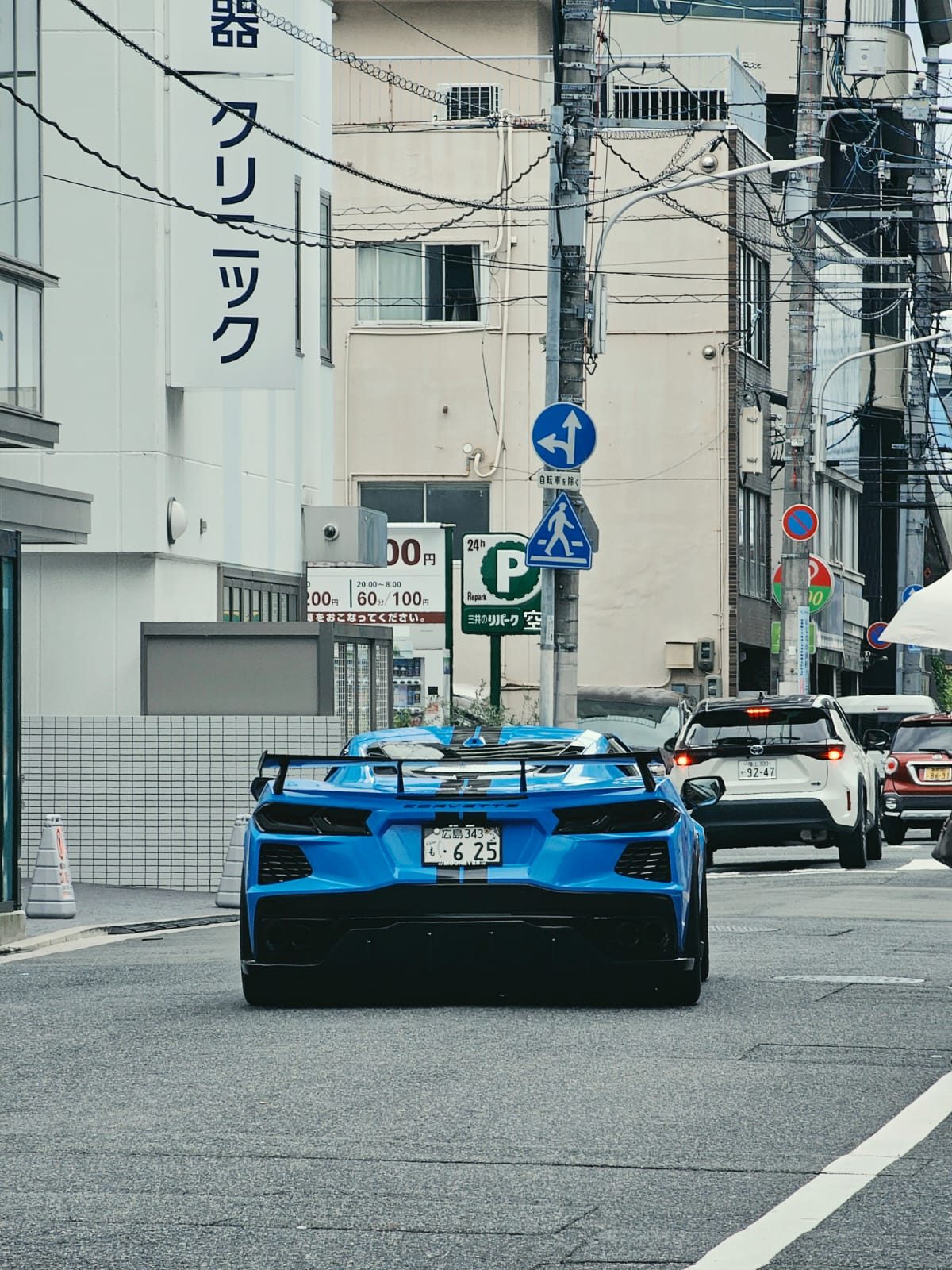 Blue Chevrolet Corvette C8 rear view on a city street