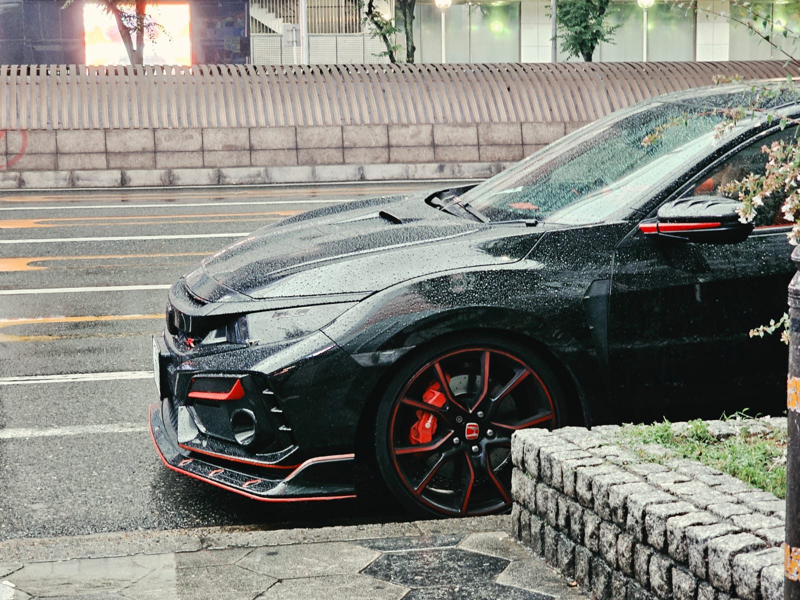 Black Honda Civic Type R with red trim parked in the rain