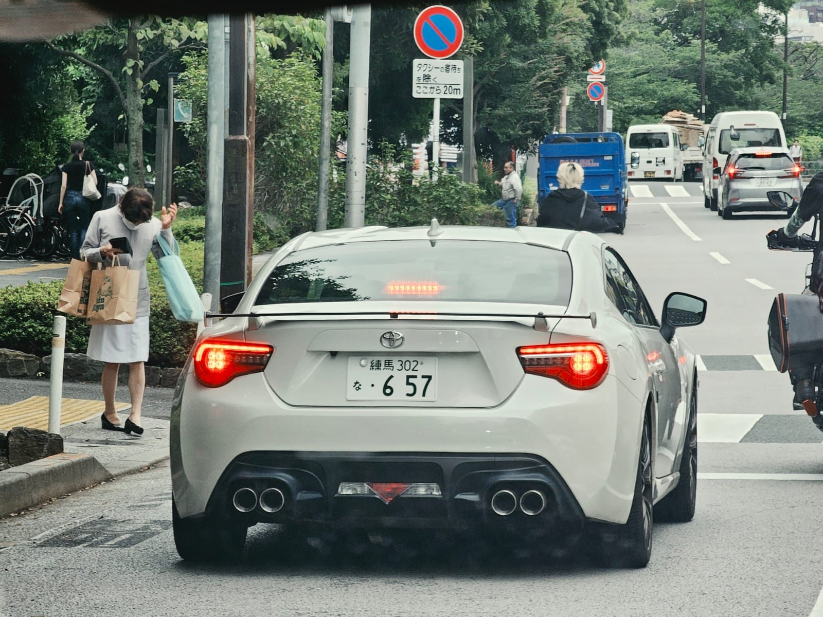 White Toyota 86 rear with taillights lit at a crossing
