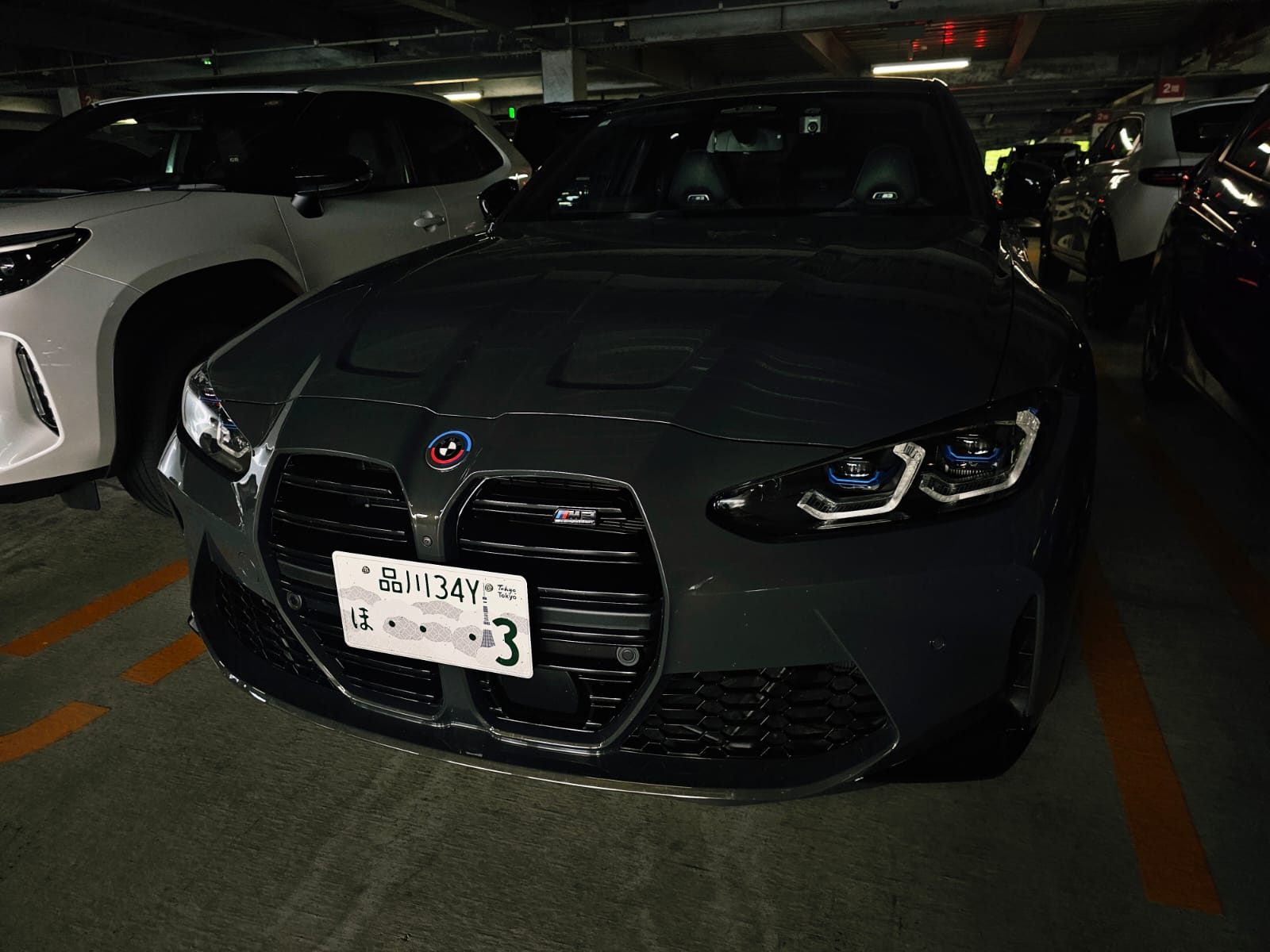 Grey BMW M3 or M4 front end in a parking garage