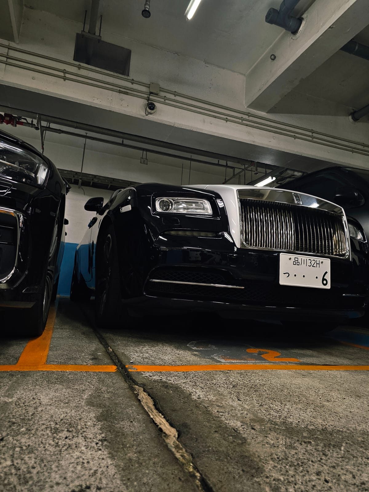 Black Rolls-Royce Wraith parked in a garage, front three-quarter view
