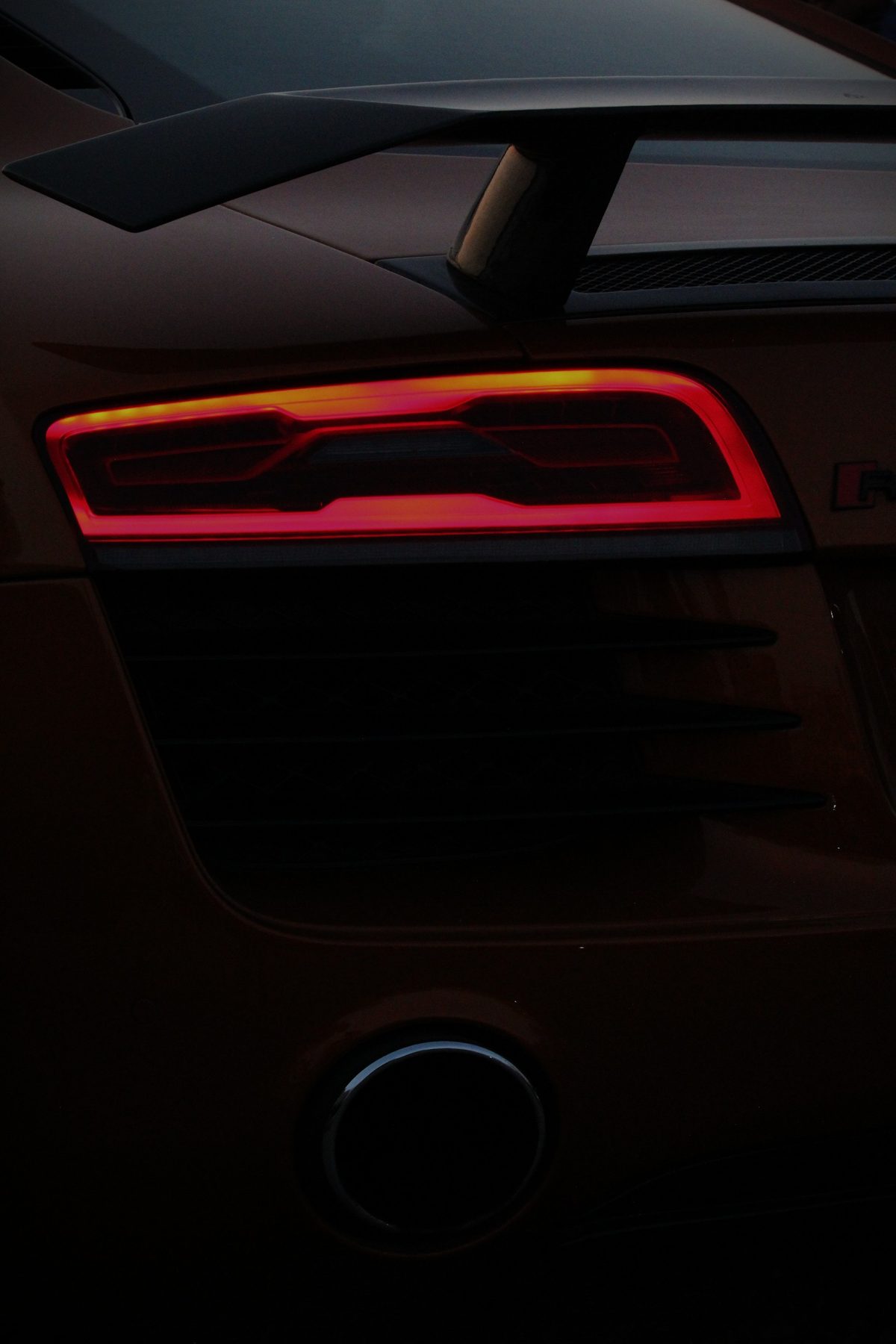 Close-up of the Audi R8's glowing red taillight at dusk