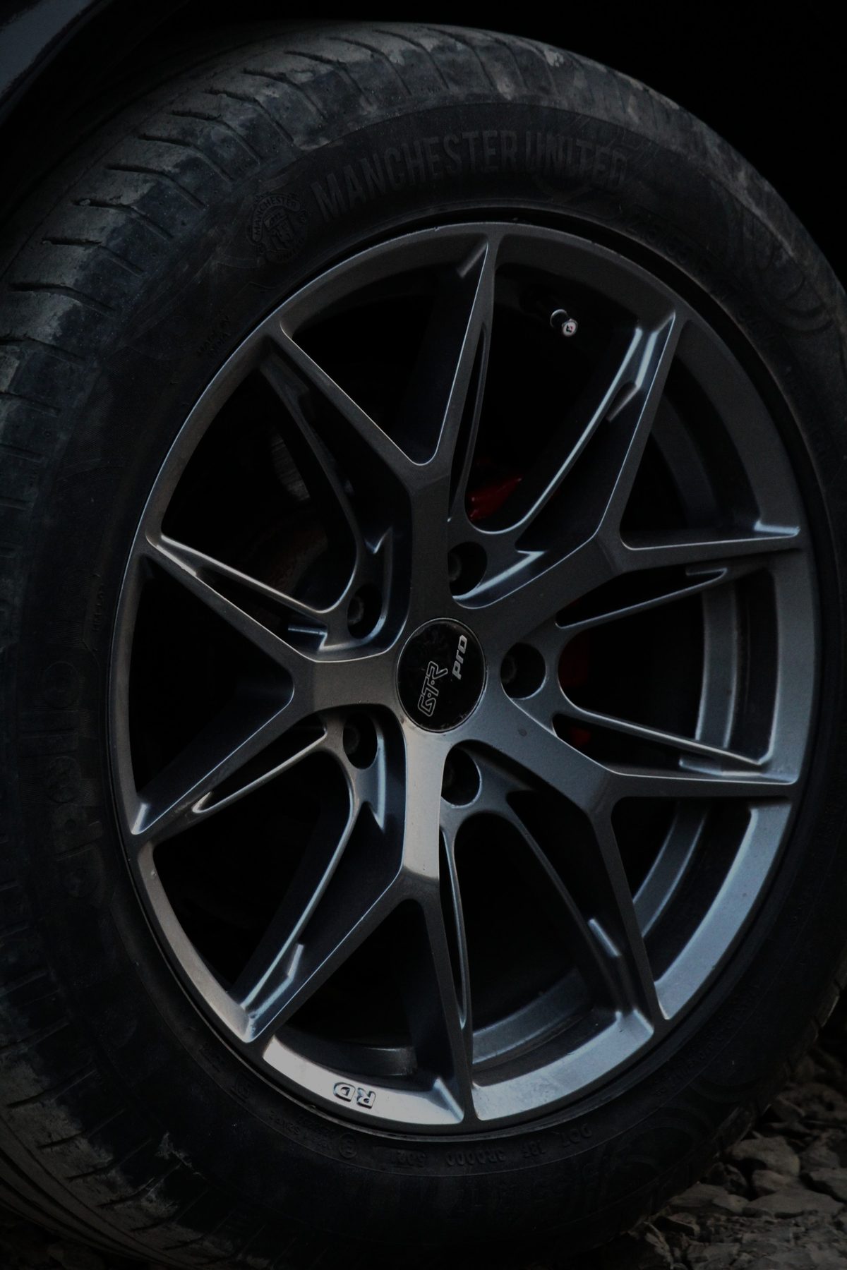 Close-up crop of the same modified grey alloy wheel