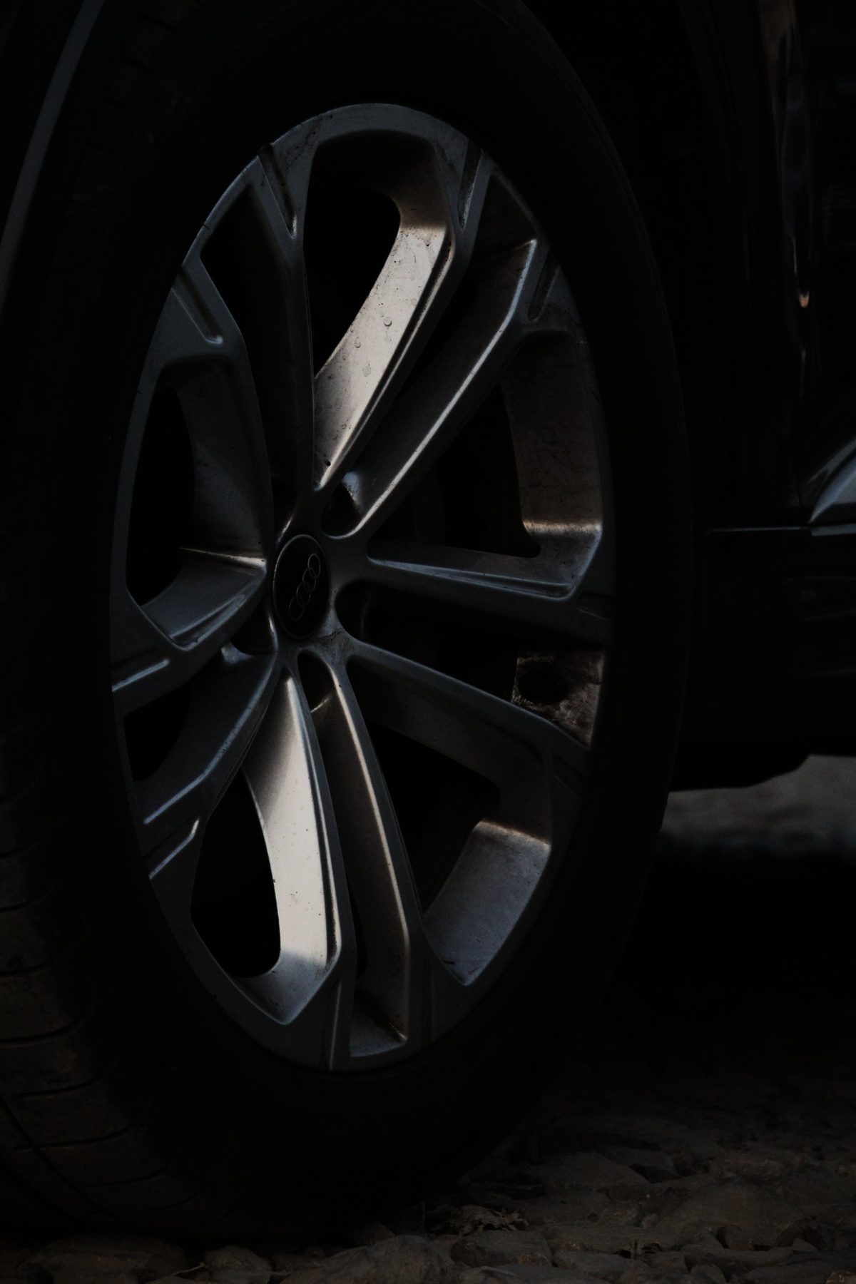 Close-up of an Audi wheel and rings badge in low light